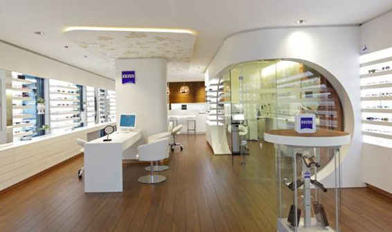 Modernes Optikergeschäft mit Brillenregalen, Beratungstischen und hochwertigem Interieur.