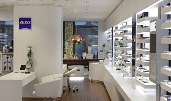 Modernes Augenoptiker-Geschäft mit Brillenregalen, Beratungstischen und heller Beleuchtung.